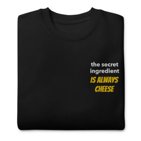 black folded sweatshirt with "cheese is always the secret ingredient"