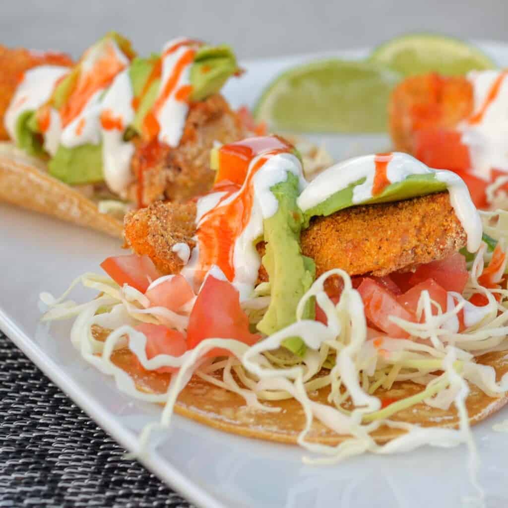 baja style fish tacos on a white plate