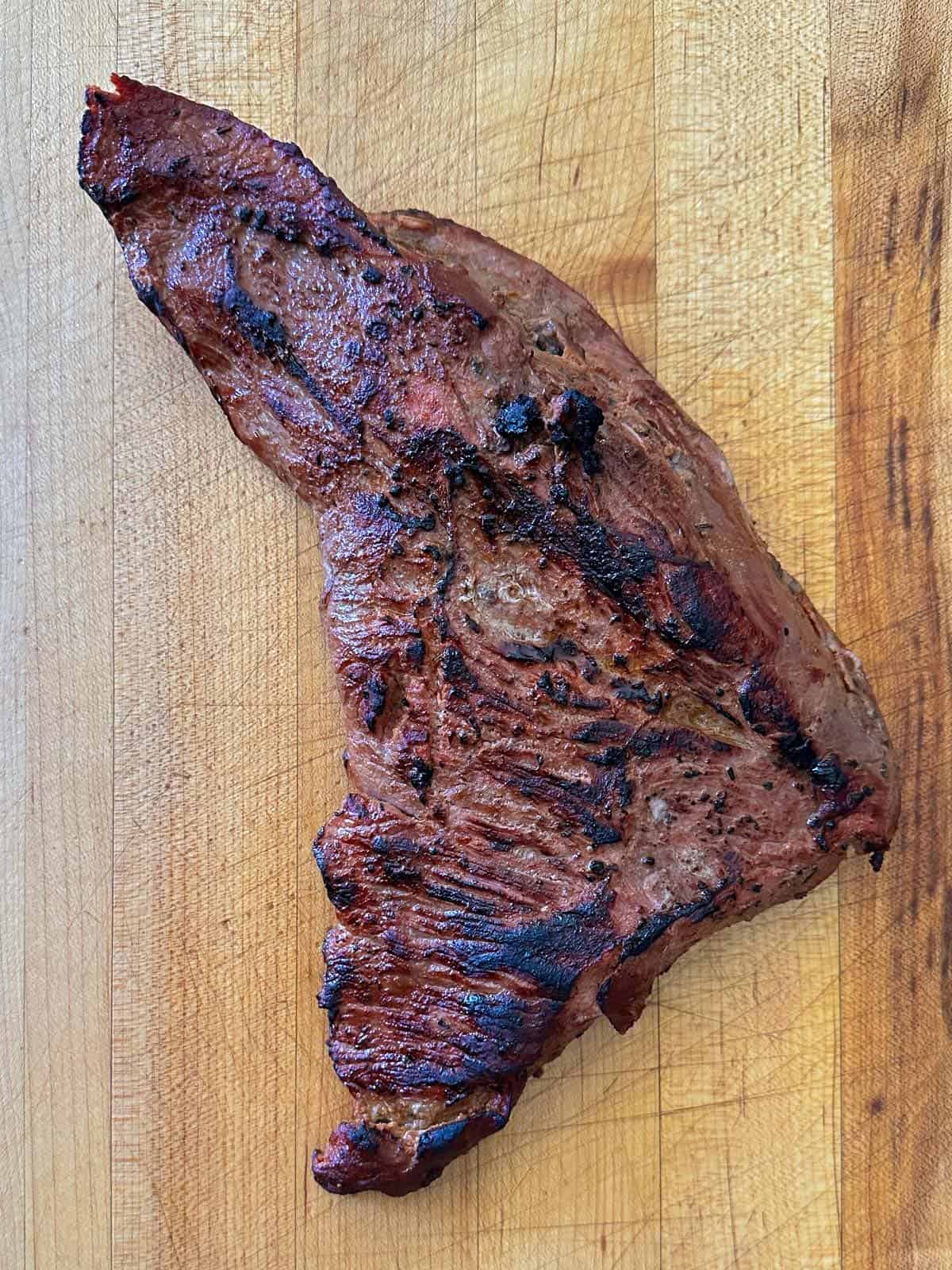 seared trip tip on a butcher block