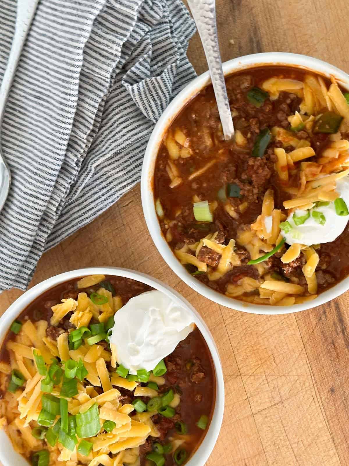 two bowls of low carb chili with a napkin and a spoon