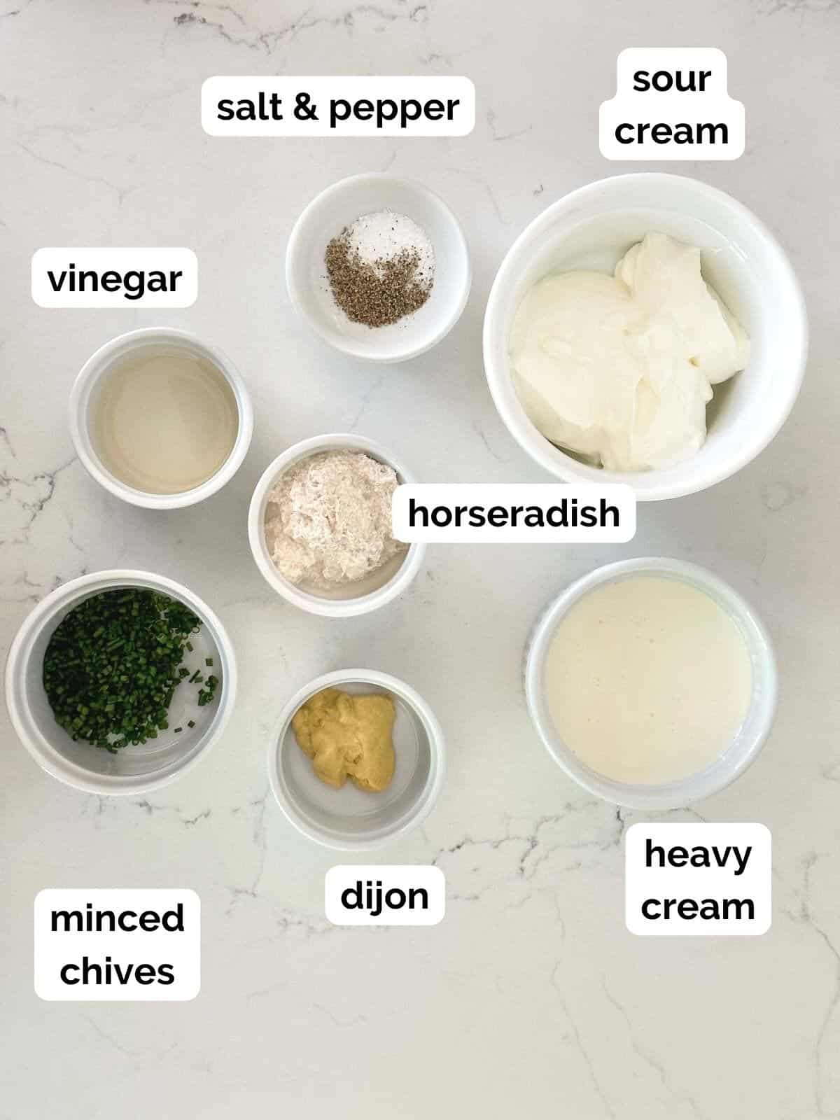 ingredients for homemade horseradish cream sauce; sour cream, heavy cream, horseradish, chives, dijon mustard, and salt and pepper