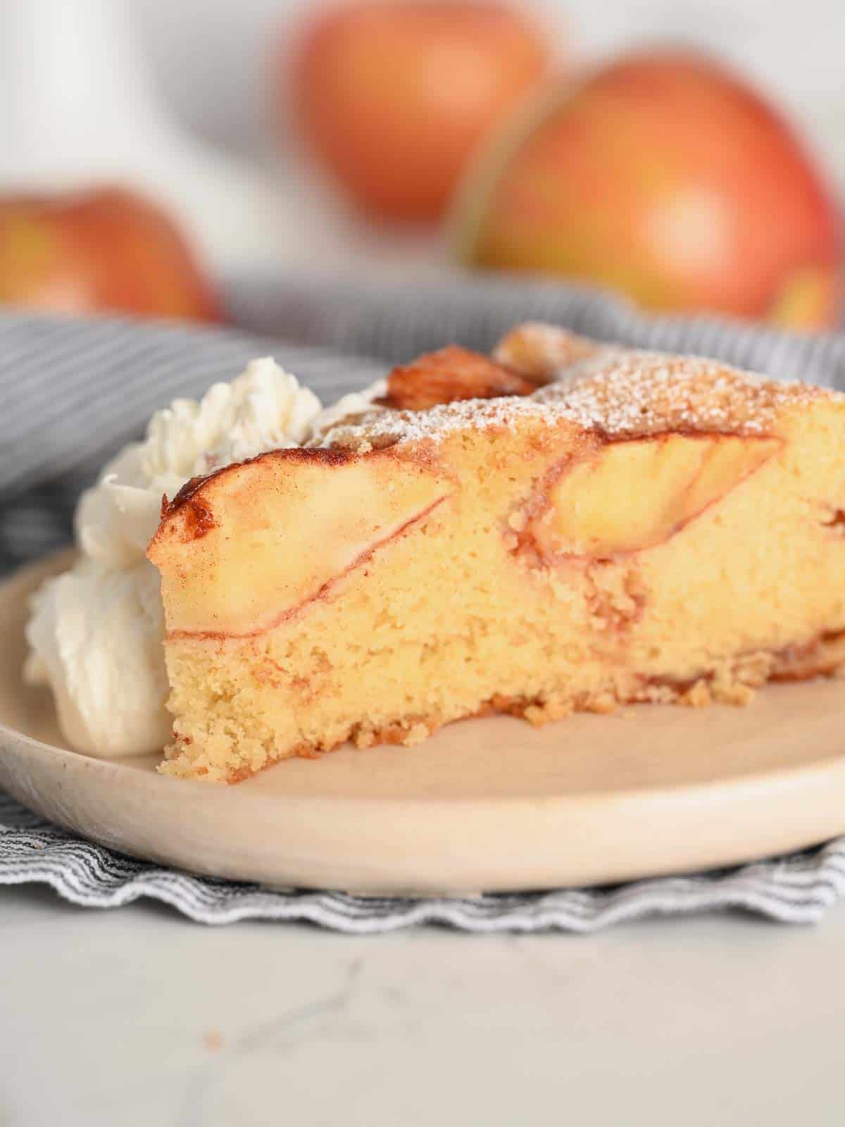 slice of sunken apple cake served with whipped cream