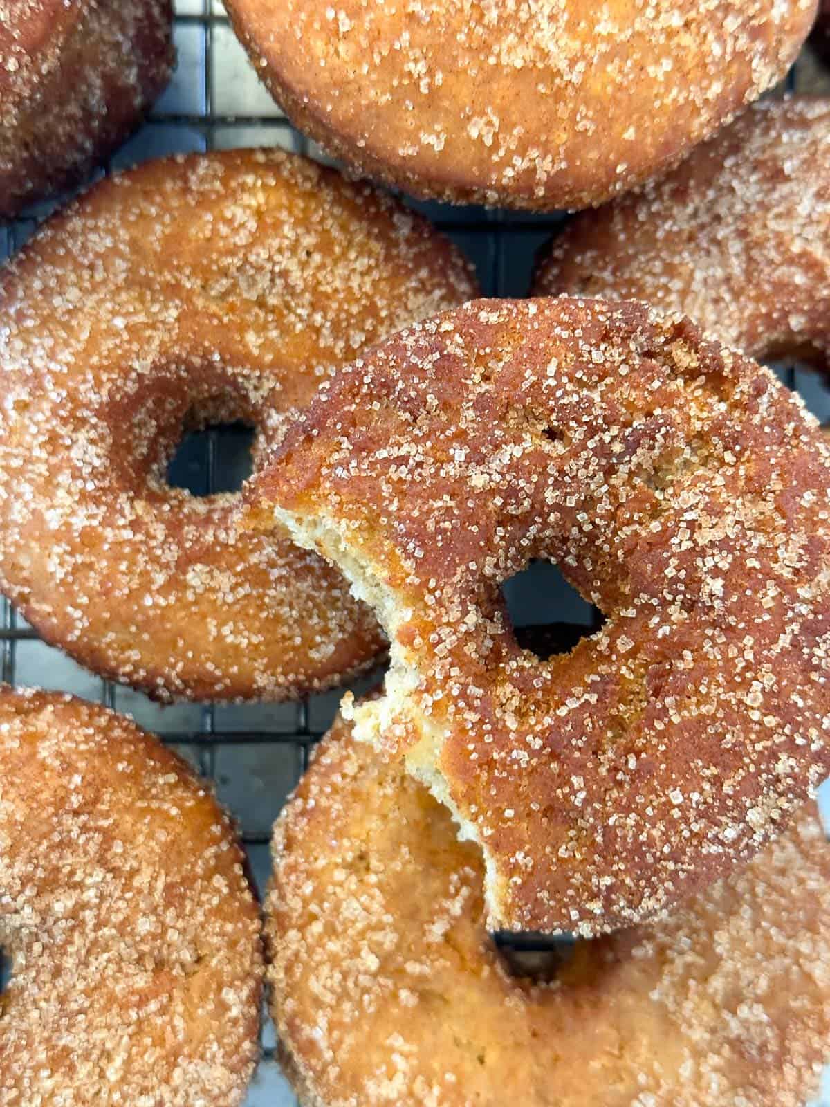 pile of apple cider donuts, tossed in cinnamon sugar