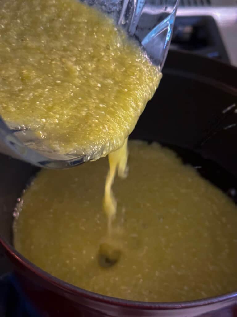 pouring salsa verde into a cast iron pan