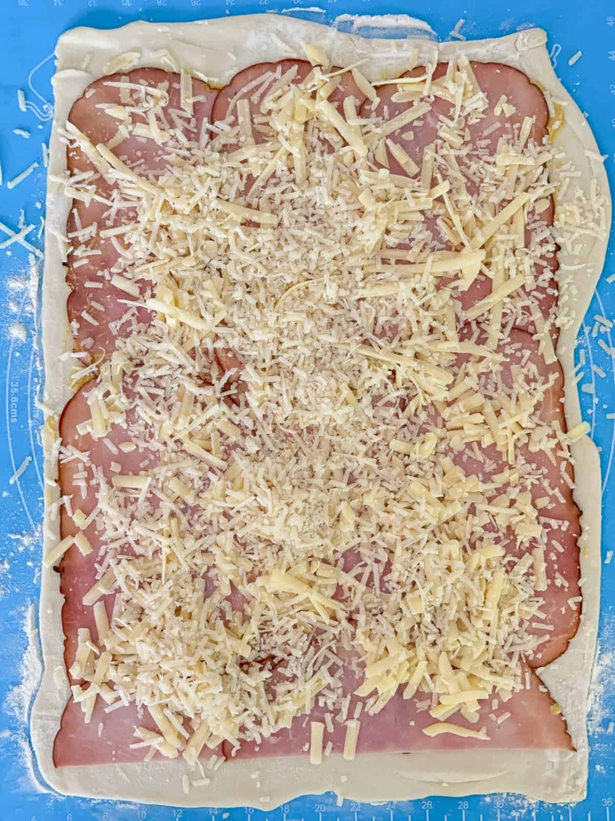 sprinkle the shredded cheese on top of the ham