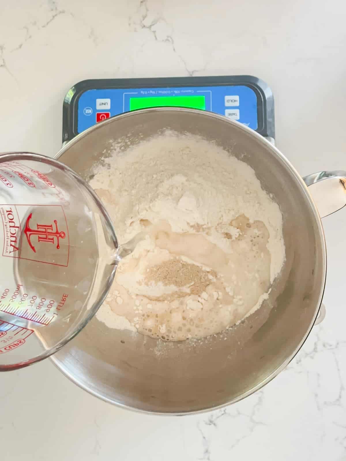 water being added to the focaccia bread ingredients