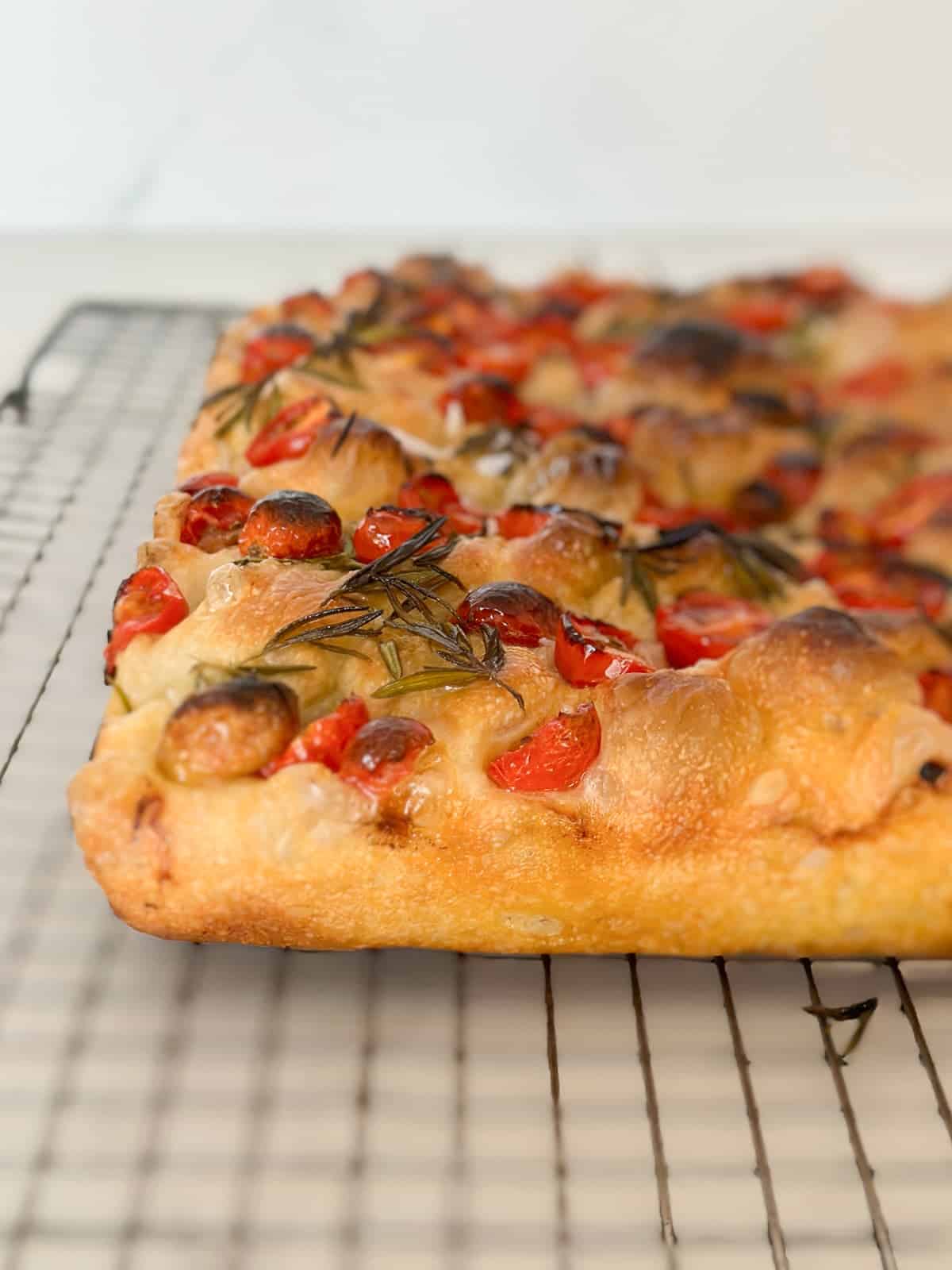 tomato focaccia bread resting on a wire rack after baking