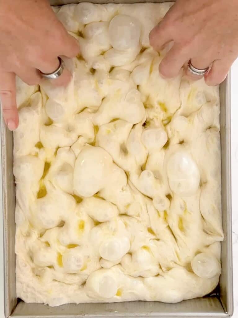 gently pressing finger into the top of the focaccia dough and gently shaking encourages the trapped air to rise to the top of the bread