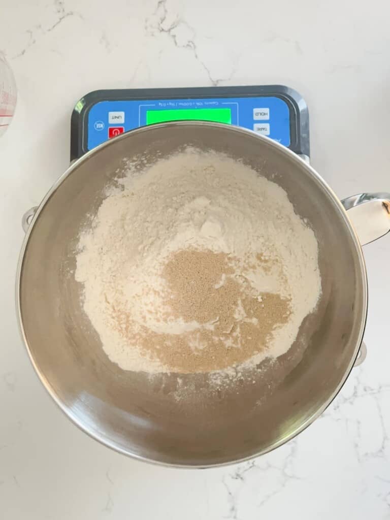 dry ingredients for focaccia bread in a bowl. everything is being measured directly on a food scale