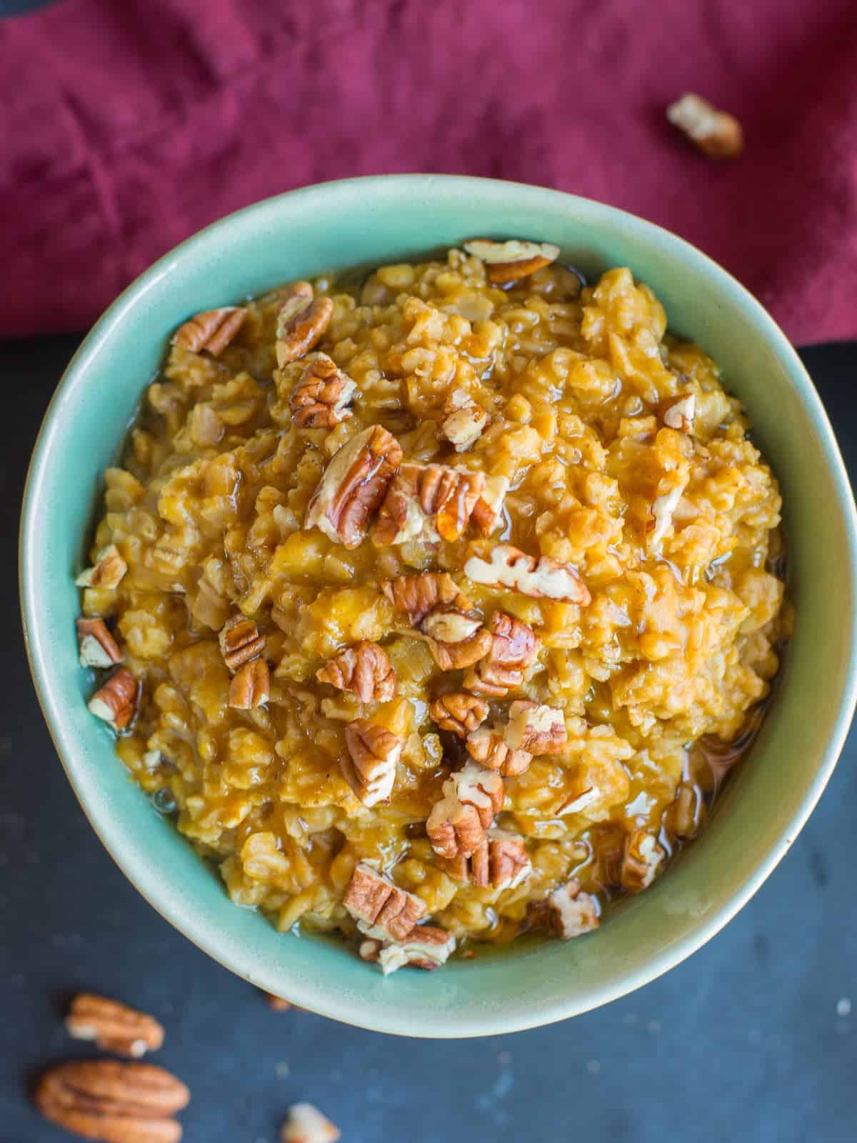 pumpkin oatmeal topped with a drizzle of maple syrup and chopped pecan