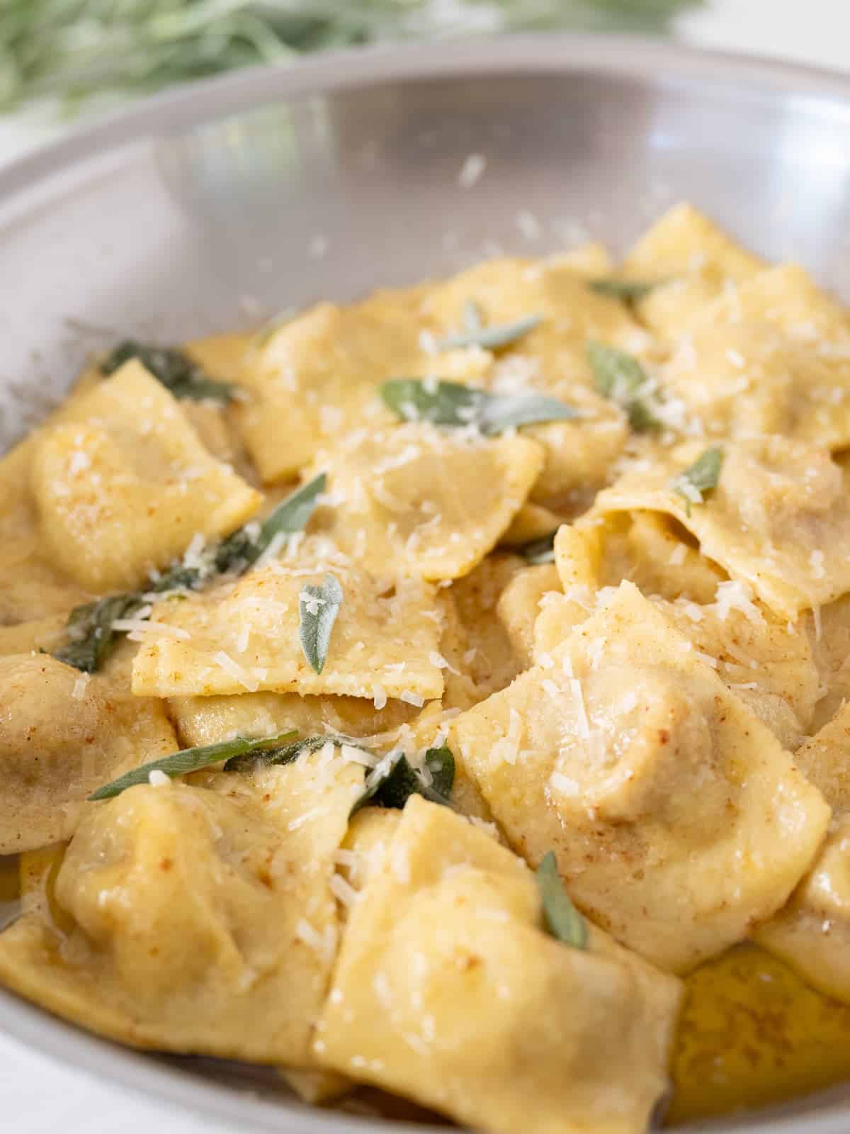 pumpkin ravioli in a saucepan with fresh sage and brown butter