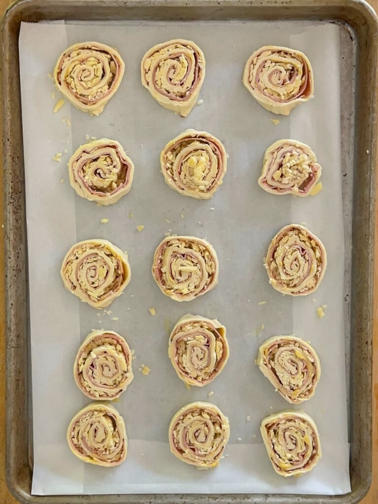 slice pinwheel set on a parchment lined baking sheet, ready for baking