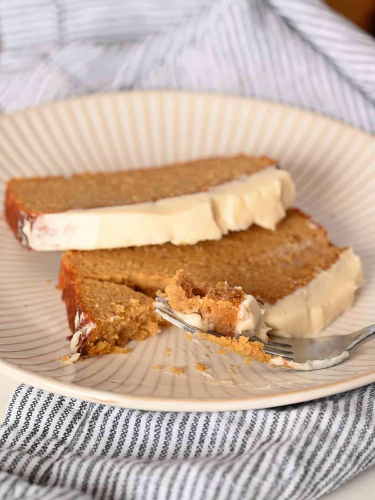 pumpkin bread frosted with cream cheese frosting with a bite taken out