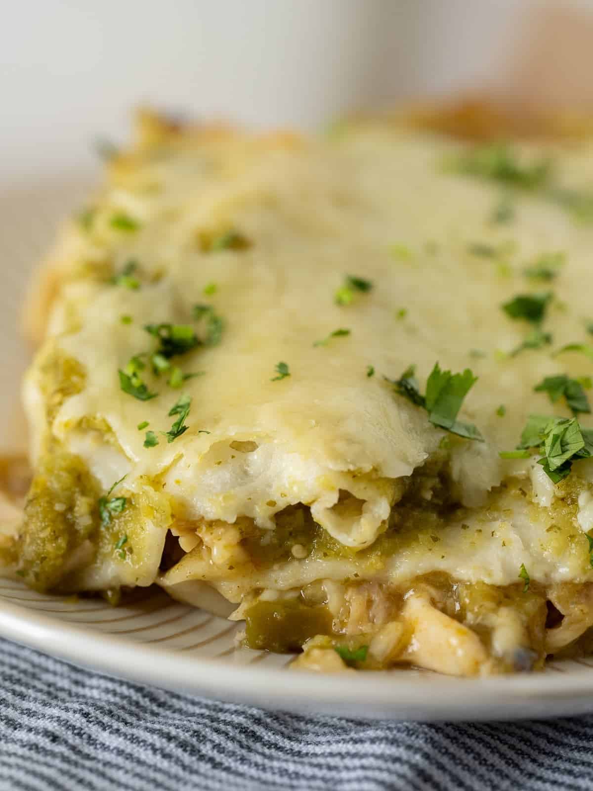 cheesy chicken enchiladas close up to show all the delicious green chile and chicken filling