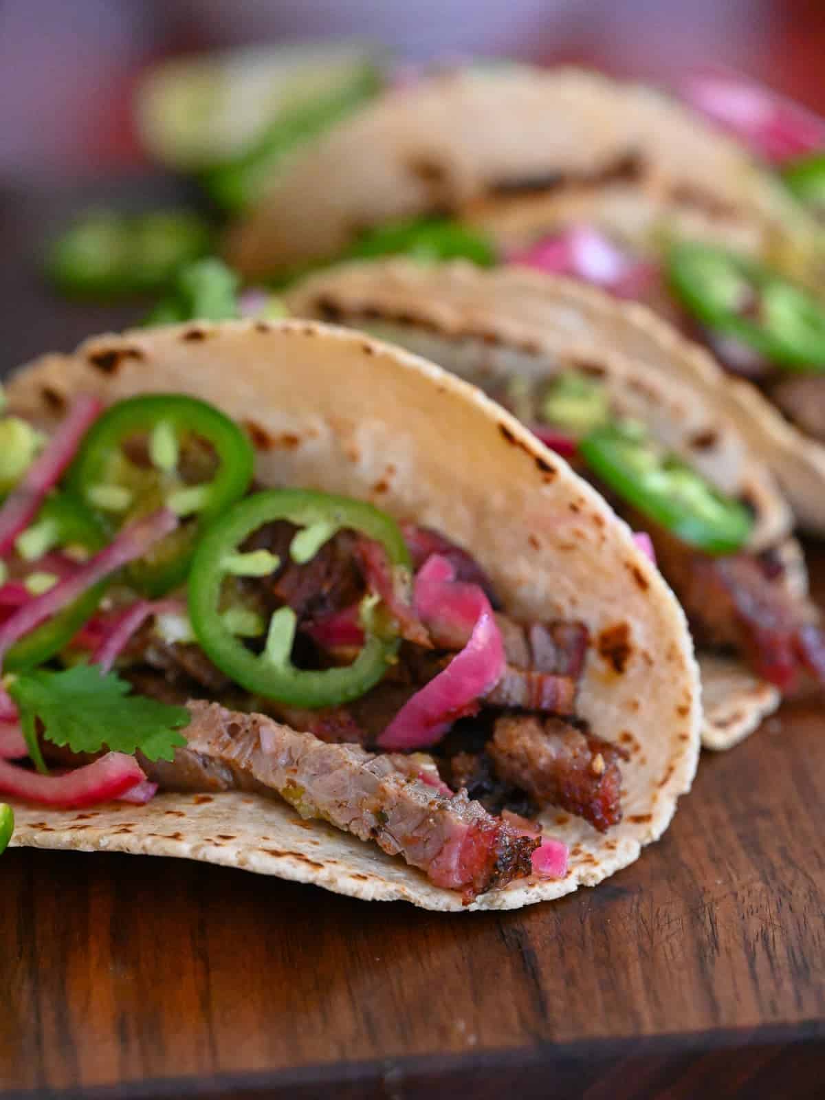 smoked brisket tacos made with leftover brisket, corn tortillas, and topped with pickled onions and sliced jalapeños