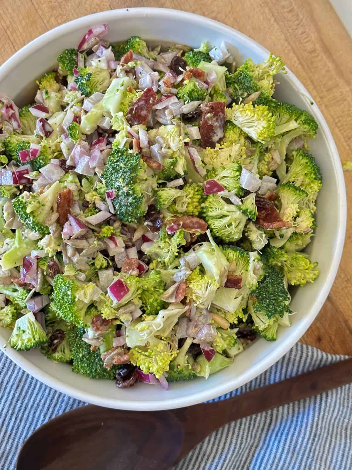 chopped broccoli salad with raisins, bacon, sunflower seeds and a sweet and tangy creamy vinaigrette dressing