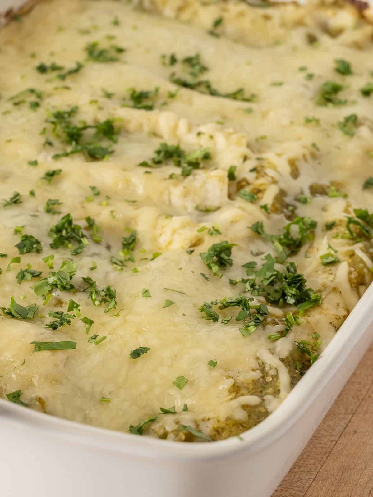 freshly back green chicken enchilas in a white casserole dish