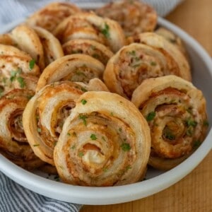 a bowl full of ham and cheese pinwheels made with puff pastry dough