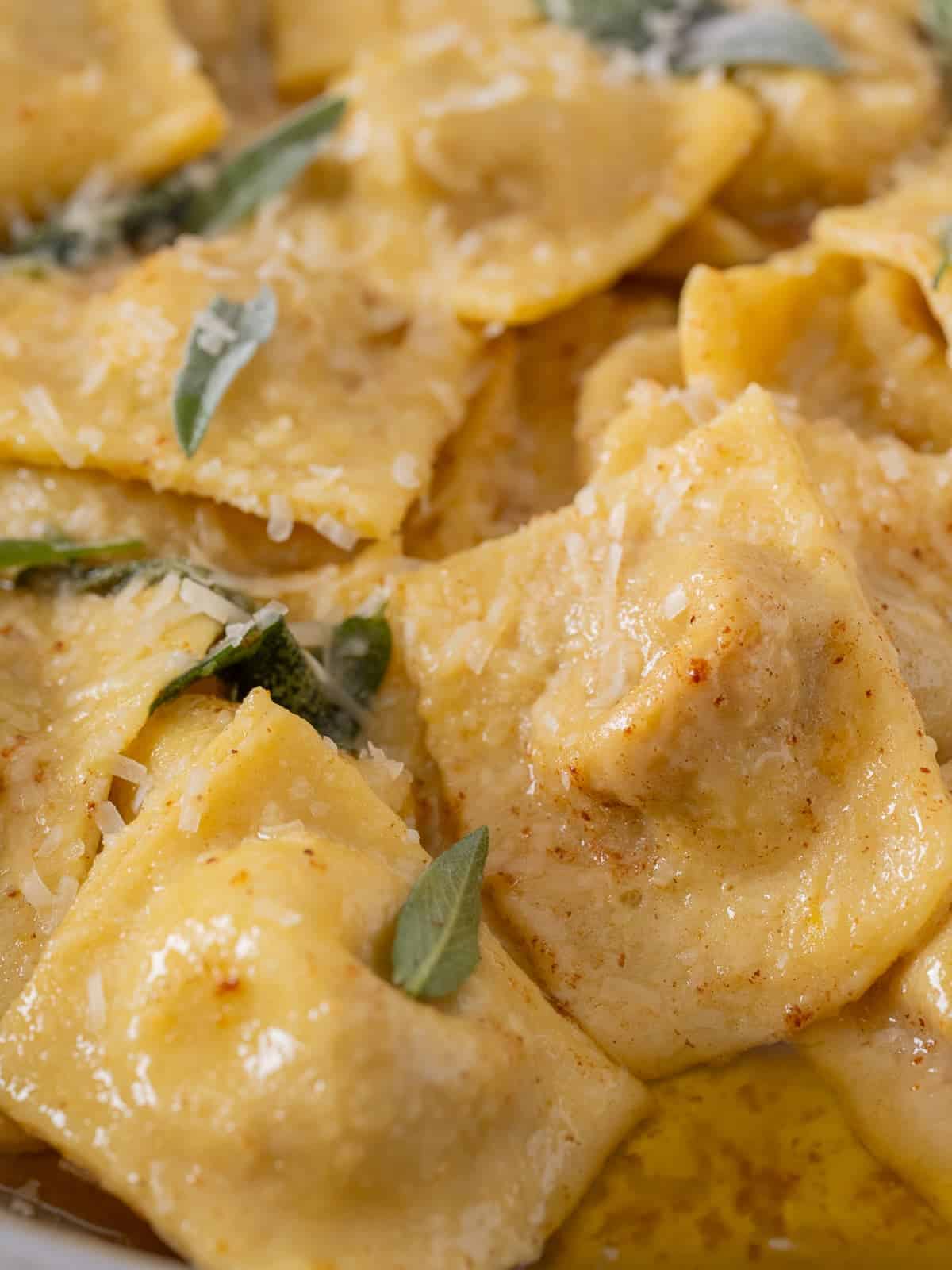 a pile of freshly cooked pumpkin ravioli in brown butter sage