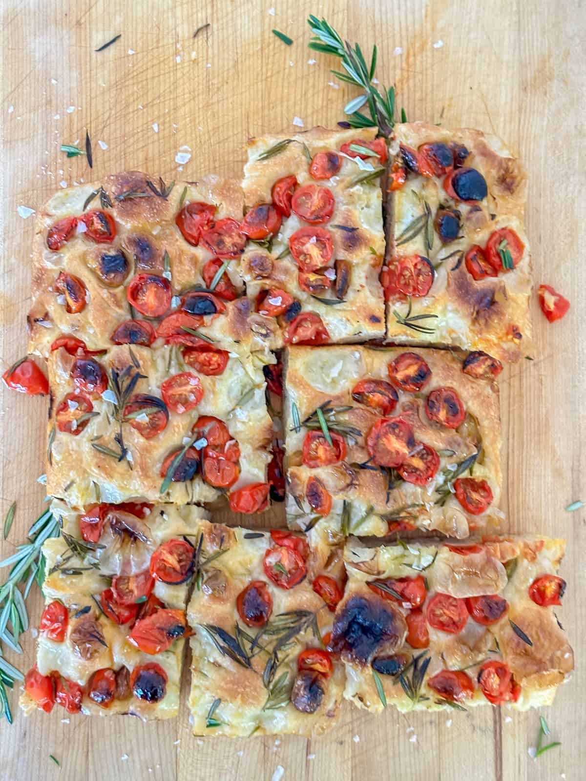 tomato focaccia bread sliced and resting on a cutting board