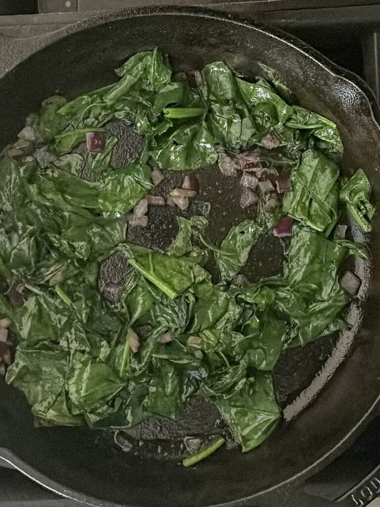 spinach and onions in a cast iron skillet