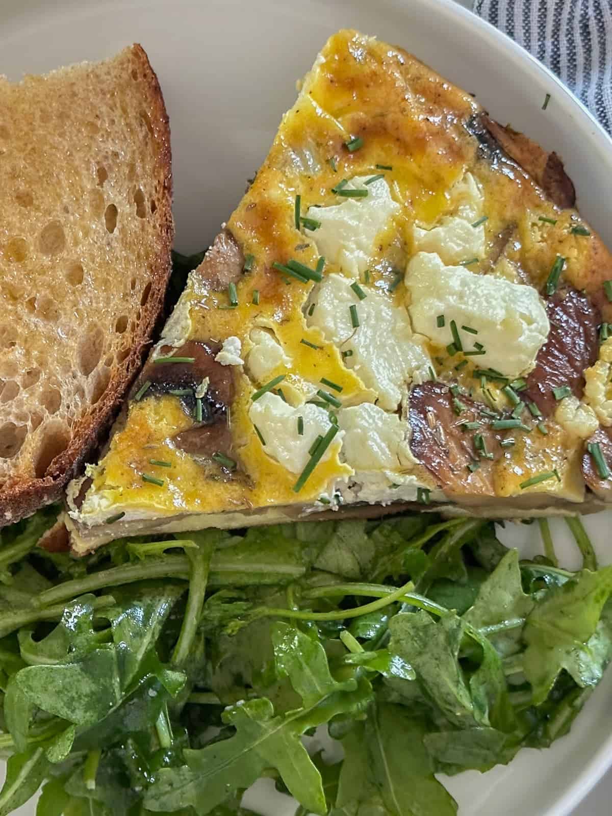 veggie frittata with mushrooms and goat cheese served with fresh toast and an arugula salad