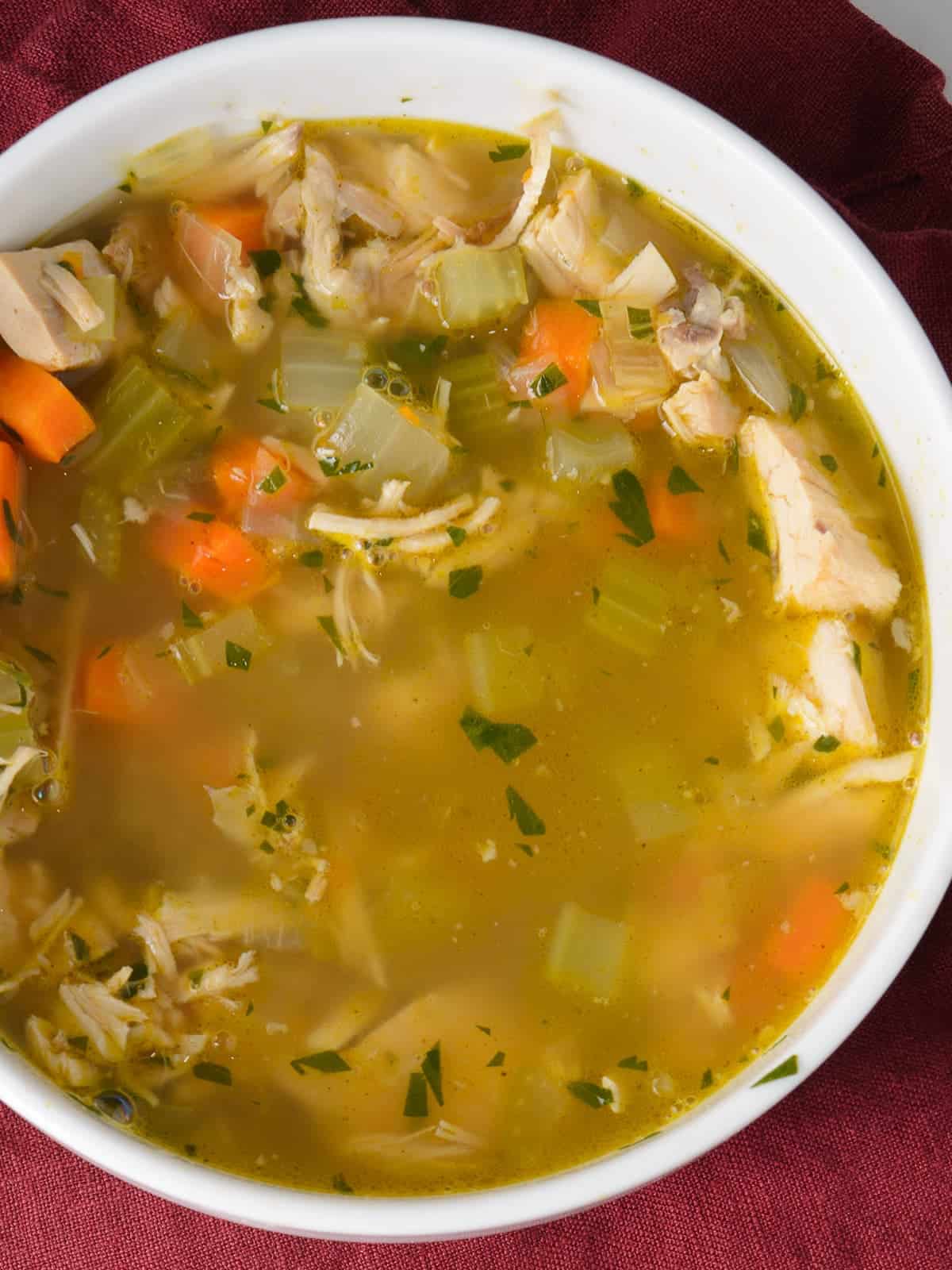 a bowl of homemade turkey soup with fresh vegetables and leftover turkey