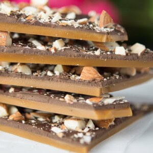 a stack of homemade butter toffee with dark chocolate and roasted almonds