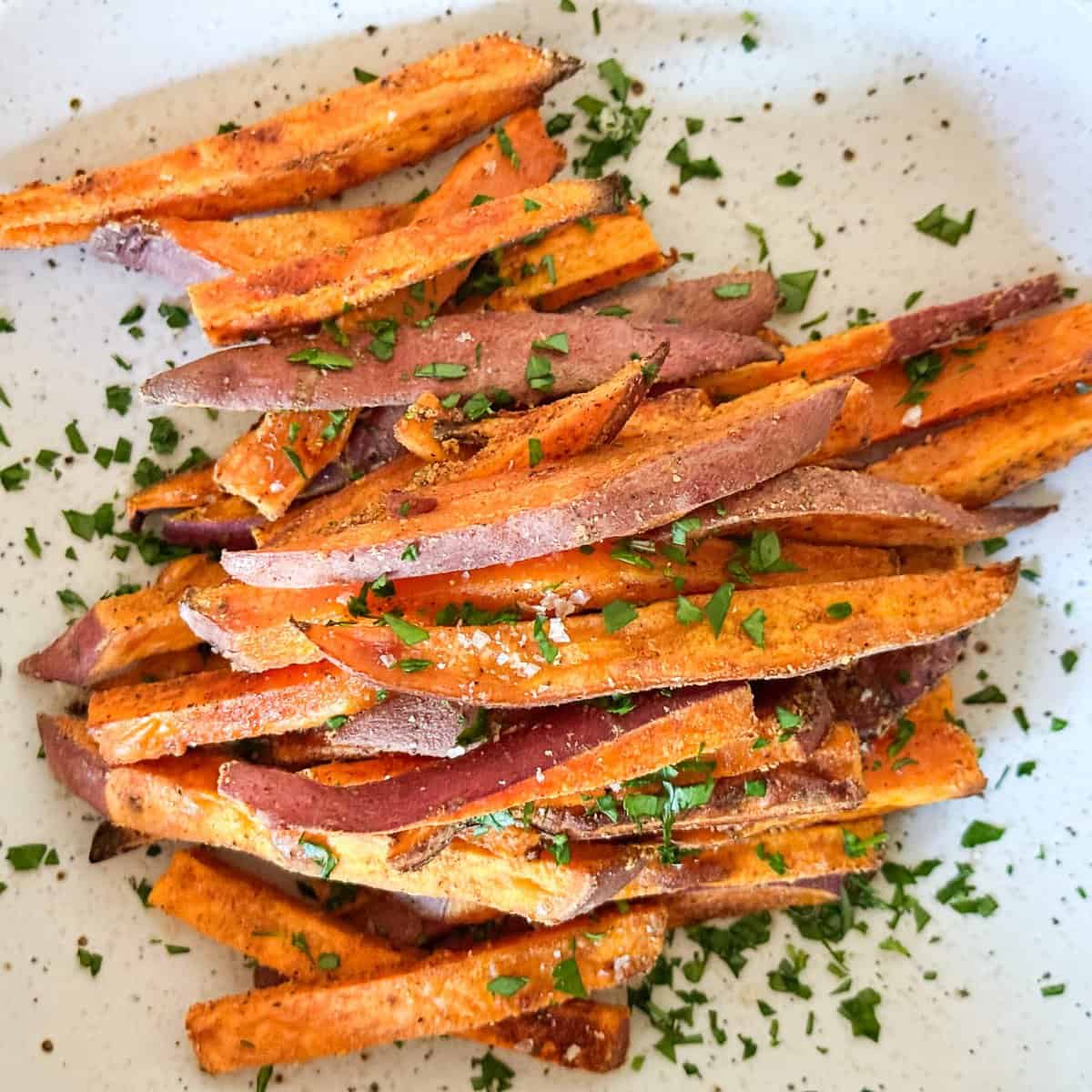 crispy sweet potato fries topped with fresh parsley and coarse salt