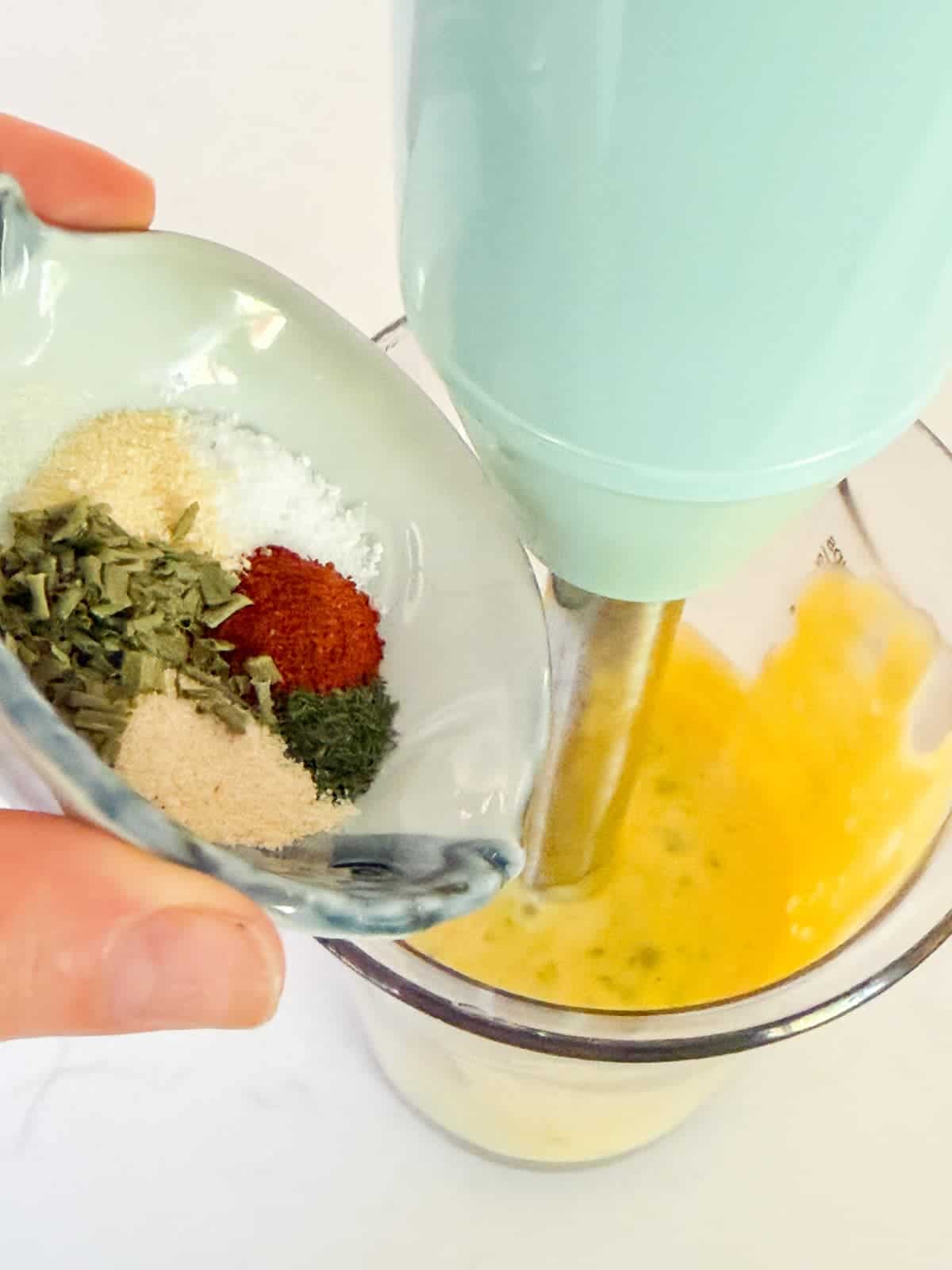 adding spices to mayonnaise to make buffalo ranch dressing