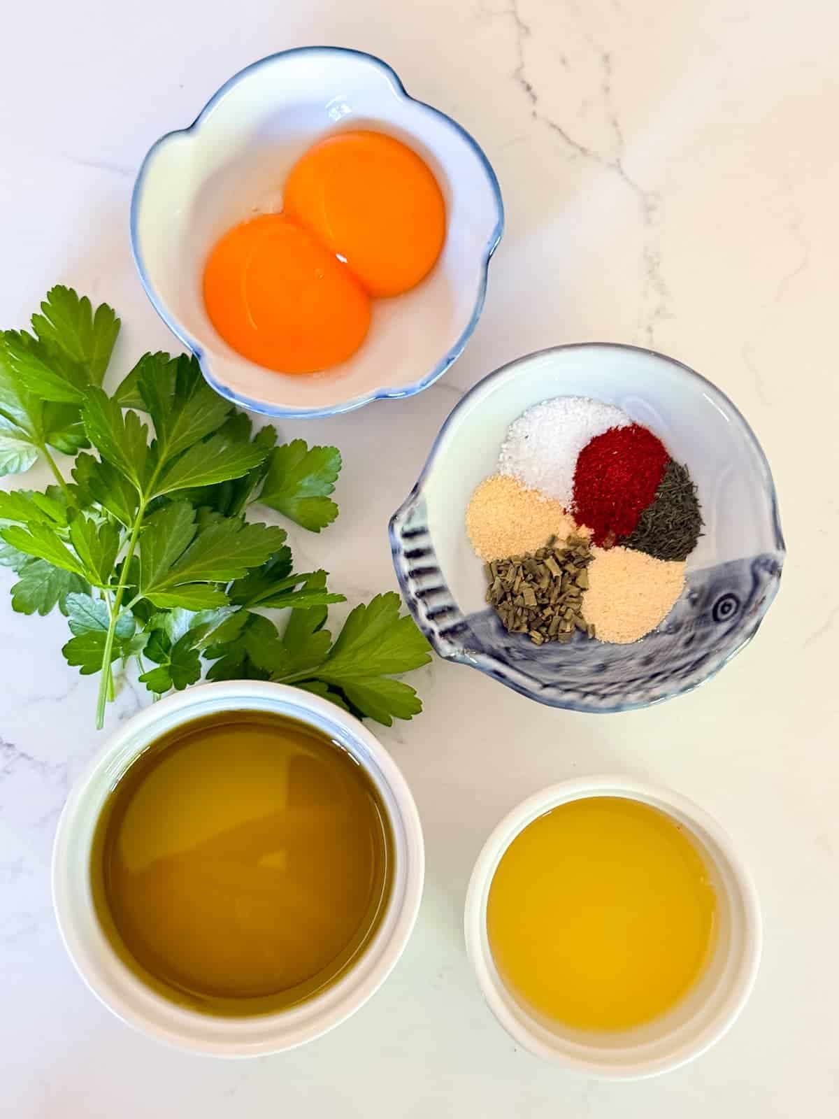 ingredients needed for diary free buffalo ranch dressing; olive oil, egg yolks, lemon juice, and spices