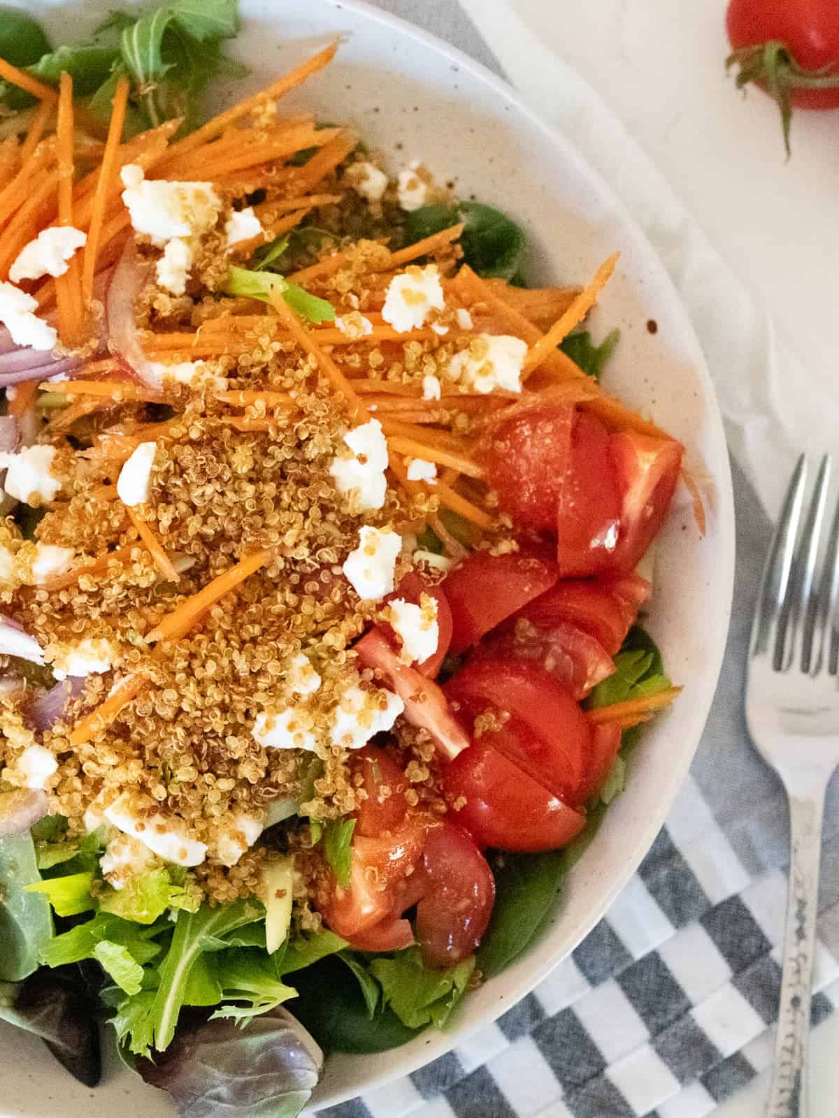 a salad topped with homemade crispy quinoa