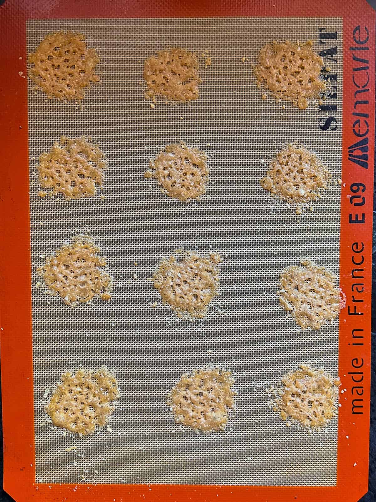 A baking sheet with a number of baked cheese crisps