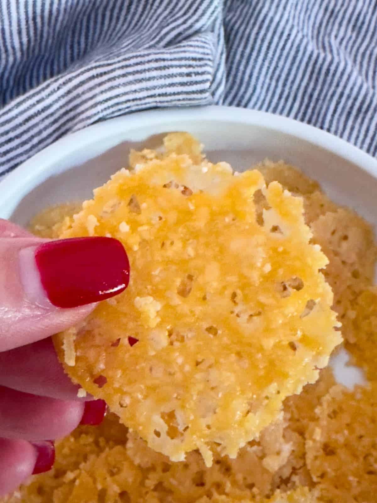 A person holding a bowl of cheese crackers.